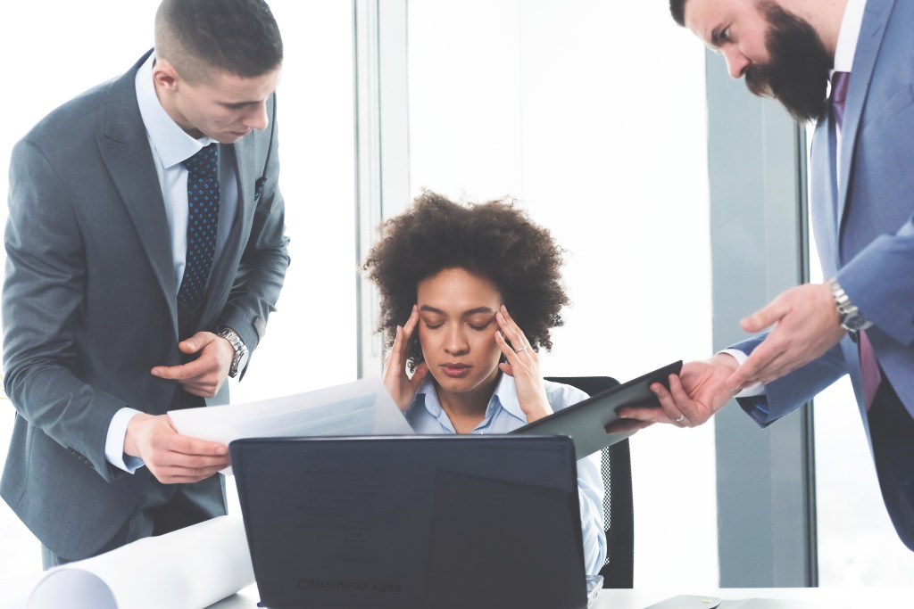 Frustrated depressed young business woman is overwhelmed.