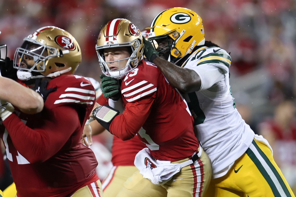 Brock Purdy is hit by linebacker De'Vondre during the 49ers' 24-21 comeback win over the Packers.