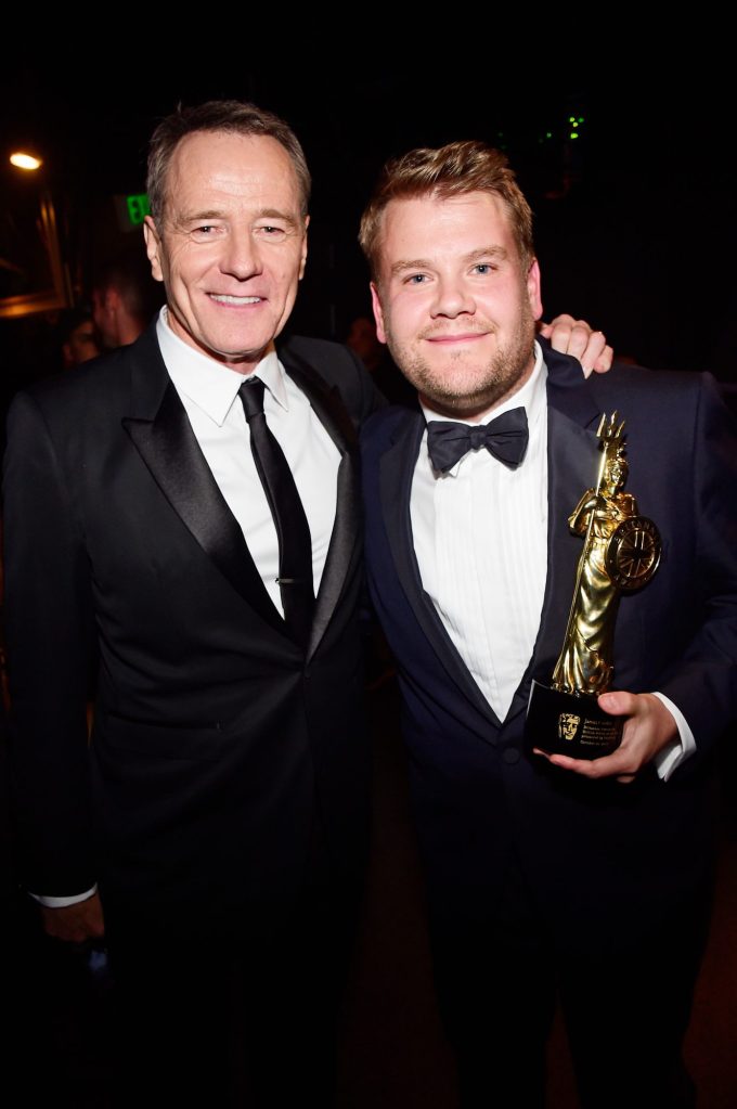 Bryan Cranston and James Corden holding the Britannia Award trophy at the 2015 Jaguar Land Rover British Academy Britannia Awards.