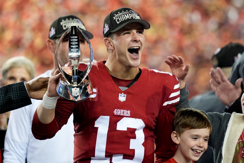 San Francisco 49ers quarterback Brock Purdy celebrates with the trophy after their win against the Detroit Lions in the NFC Championship NFL football game in Santa Clara, Calif., Sunday, Jan. 28, 2024.