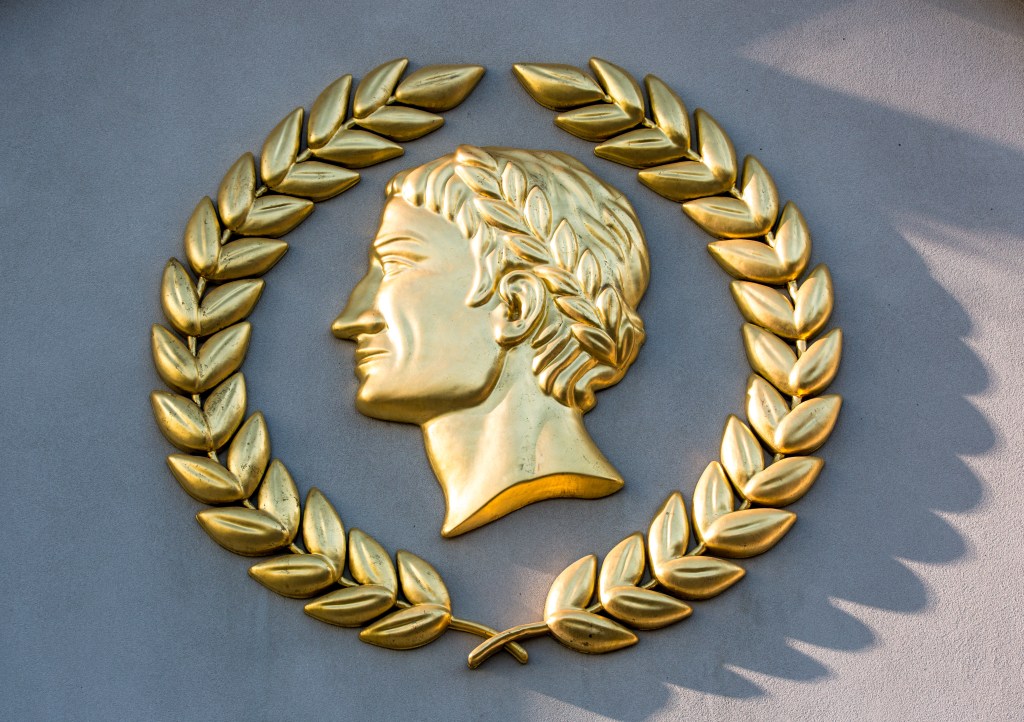 A gold-plated Caesars Palace Hotel & Casino logo.