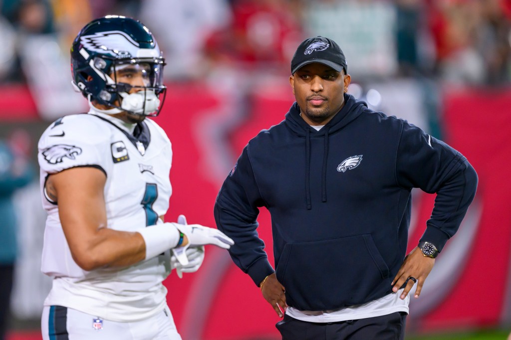 Brian Johnson watches quarterback Jalen Hurts (1) practice on the field before an NFL wild-card playoff football game against the Tampa Bay Buccaneers.