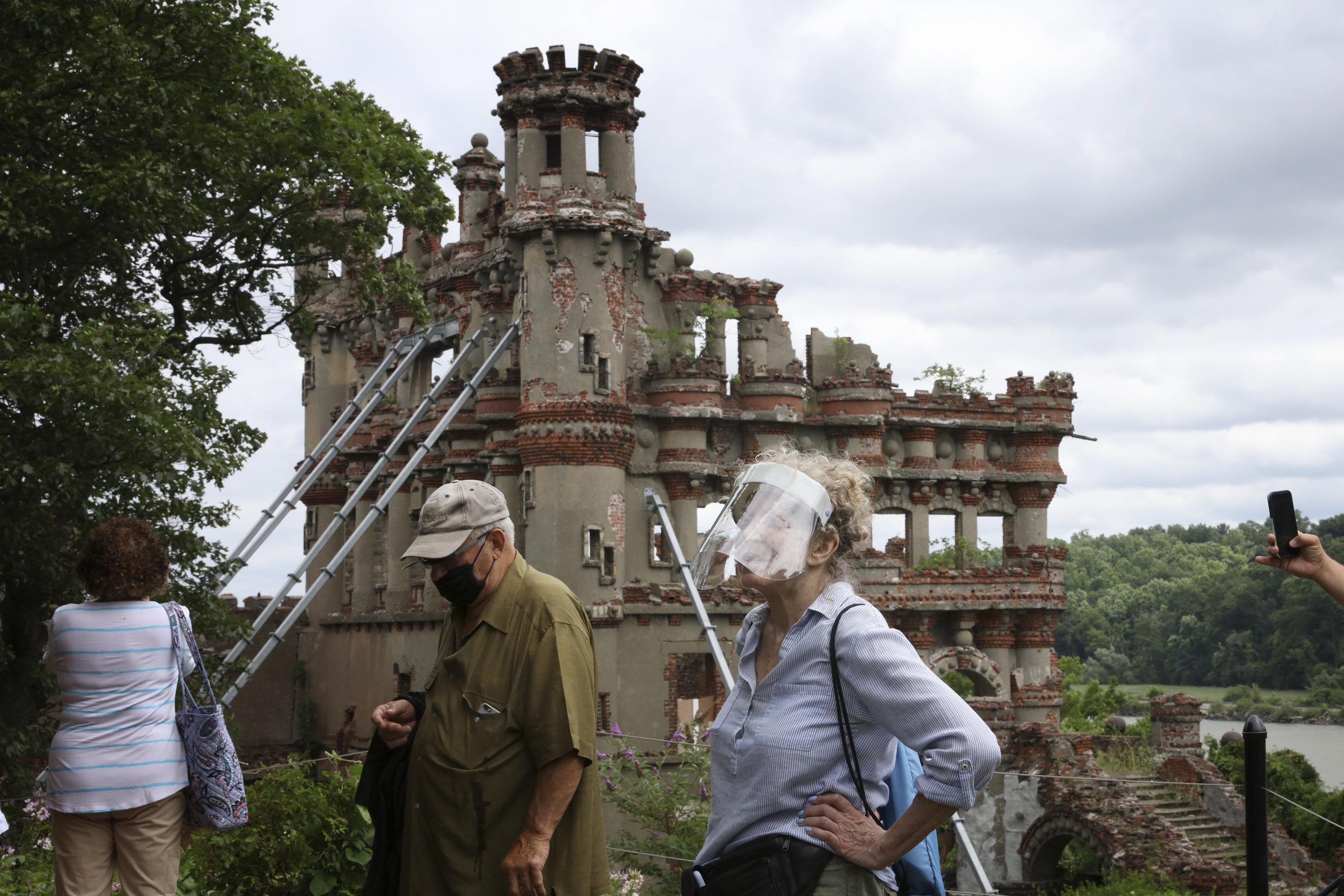 People visiting Bannerman's Castle on Pollepel Island in New York, with ruins of a building in background.