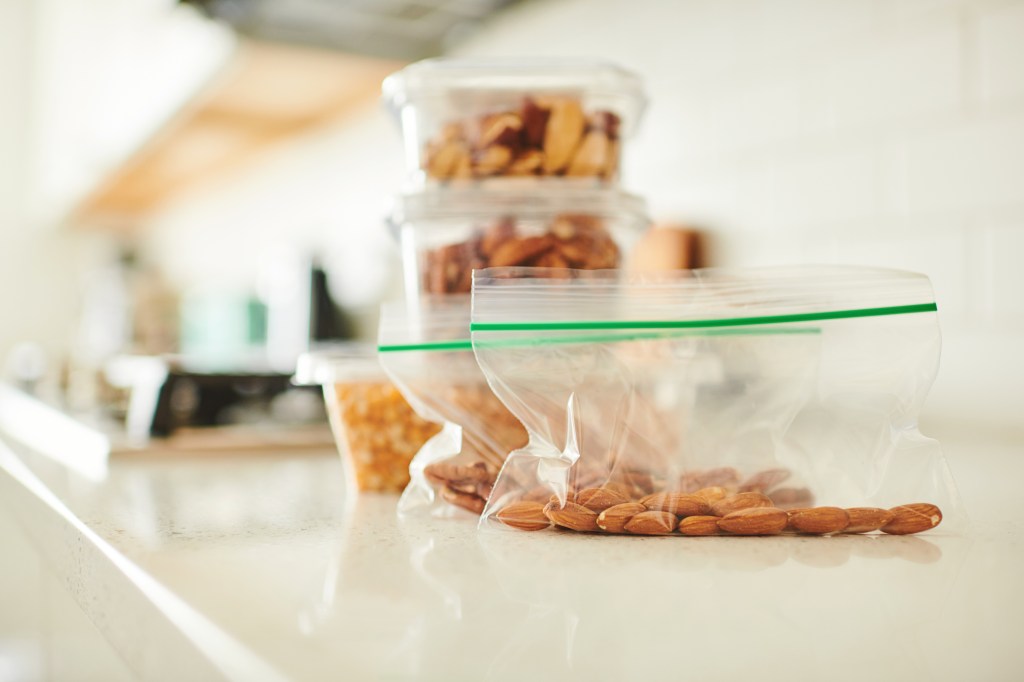 Assorted nuts in plastic containers on a counter in a bright modern kitchen