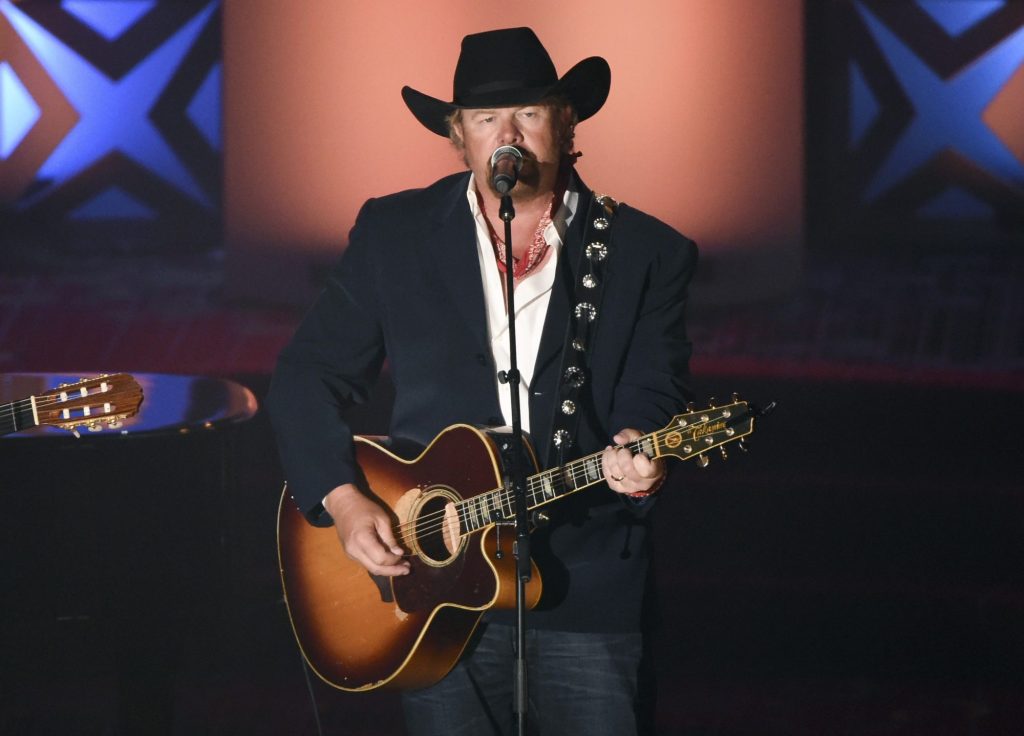 Toby Keith performing with a guitar on stage during the 46th annual Songwriters Hall of Fame Induction and Awards Gala in June 2015.