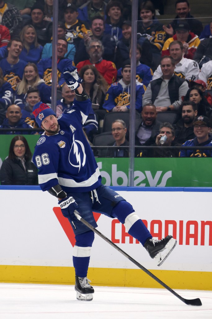 Nikita Kucherov #86 in blue uniform stick handling on ice, watched by crowd, during the 2024 NHL All-Star Skills Competition in Toronto.