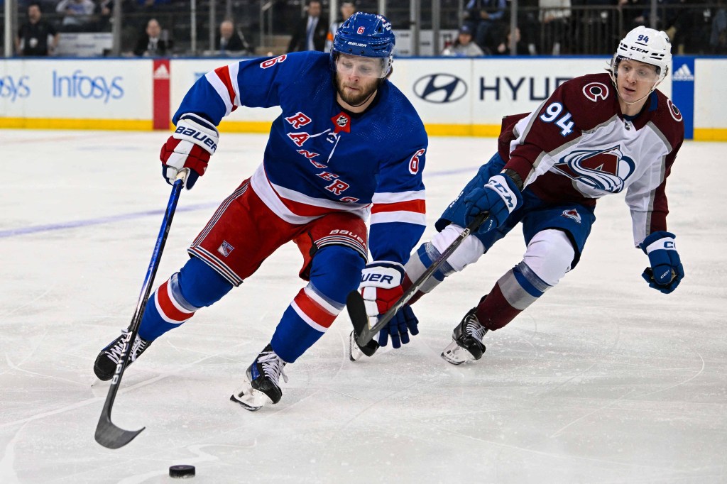 Zac Jones fights for the puck during the Rangers' win over the Avalanche.