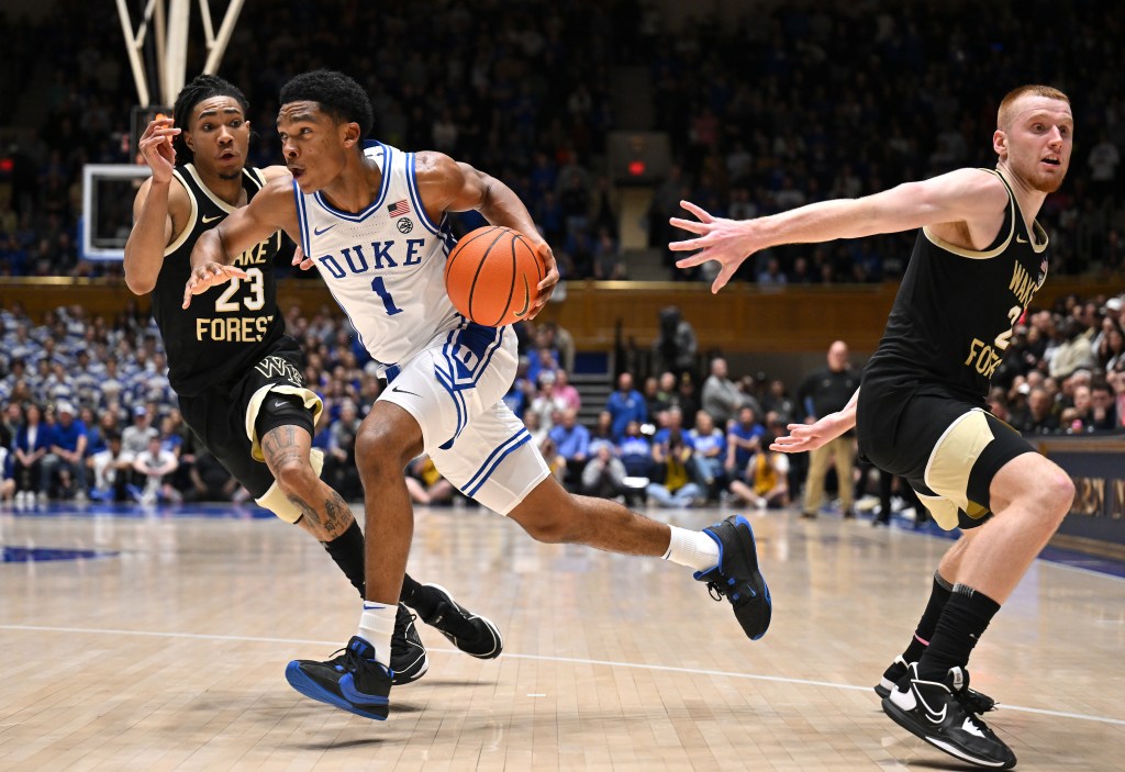 Caleb Foster #1 of the Duke Blue Devils drives to the basket between Hunter Sallis #23 and Cameron Hildreth #2 of the Wake Forest Demon Deacons during the second  half of the game at Cameron Indoor Stadium.