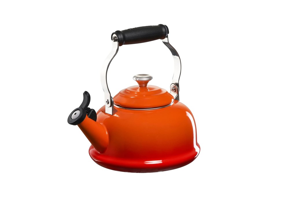 A red tea kettle with a black handle