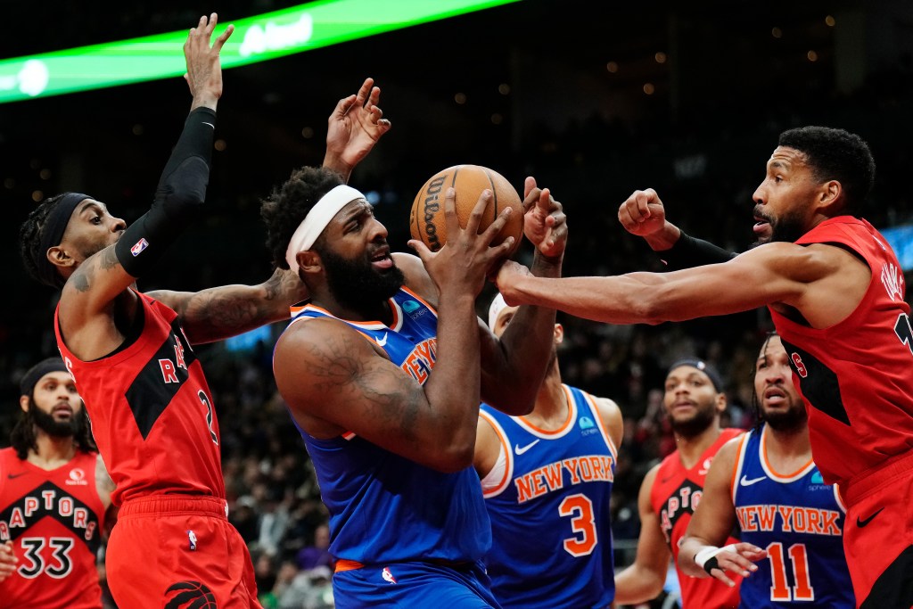 Knicks center Mitchell Robinson, center, is fouled by Toronto Raptors forward Garrett Temple