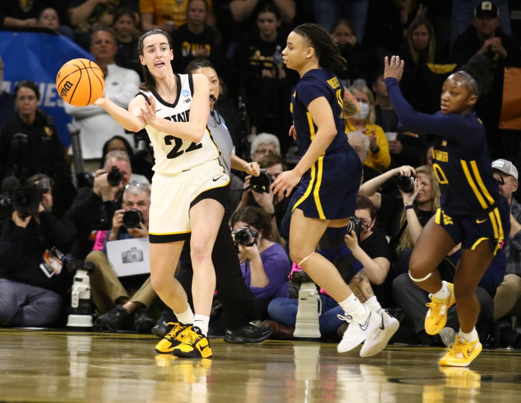 Caitlin Clark #22 of the Iowa Hawkeyes passes the ball in the second half against guard J.J. Quinerly #11 of the West Virginia Mountaineers during their second round match-up in the 2024 NCAA Division 1 Women's Basketball Championship