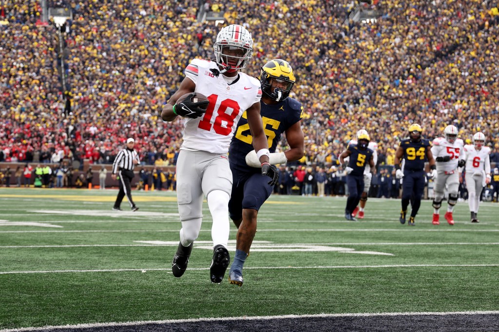 Marvin Harrison Jr. of Ohio State Buckeyes scoring a touchdown against Junior Colson of the Michigan Wolverines during a football game