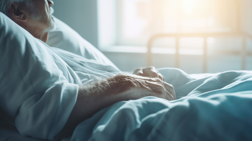 Close-up of elderly man lying in bed, receiving long-term care and physical therapy