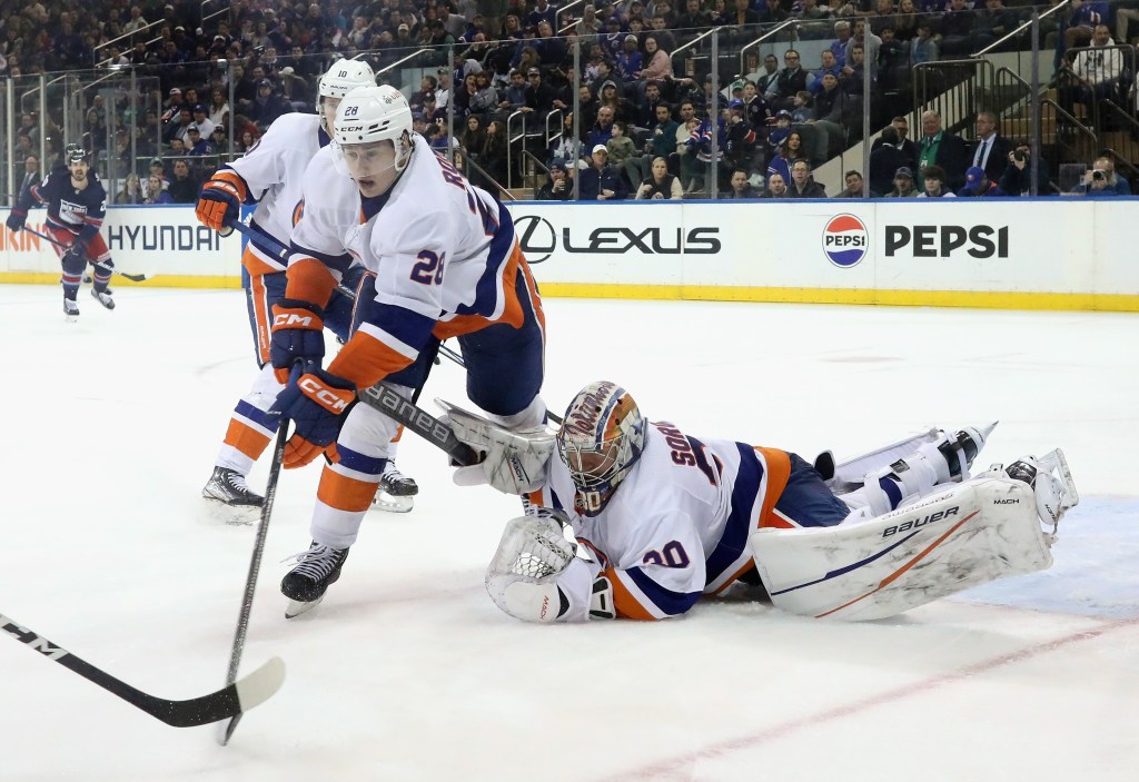 Alexander Romanov #28 and Ilya Sorokin #30 of the New York Islanders defend against the New York Rangers at Madison Square Garden.