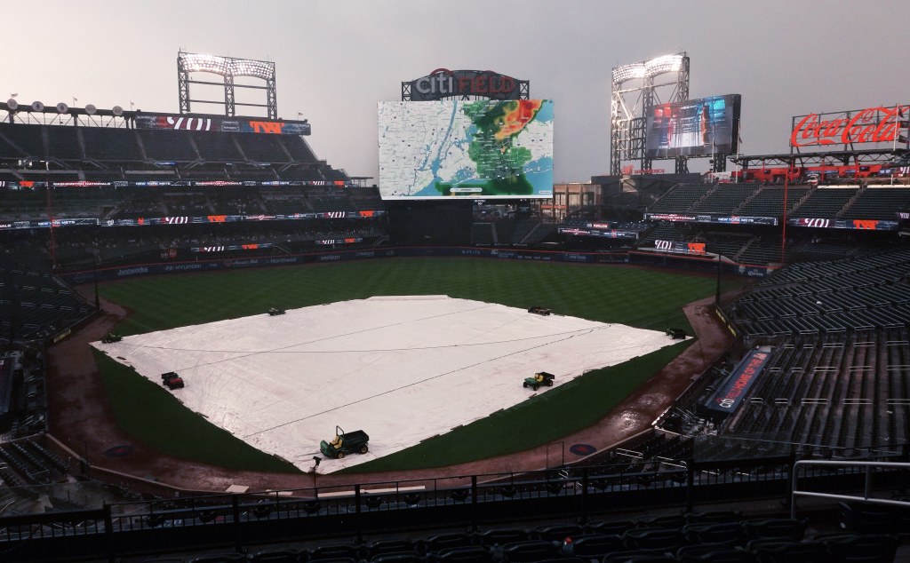 New York Mets fans at Citi Field watching an approaching weather storm on the giant scoreboard during a rain delay before a game against the Washington Nationals