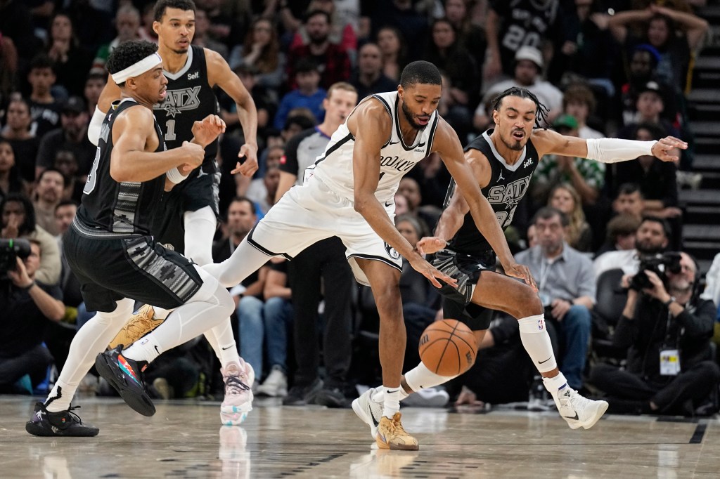 Antonio Spurs forward Keldon Johnson (3) and guard Tre Jones (33) battle for the loose ball with Brooklyn Nets forward Mikal Bridges (1) during overtime at Moody Center.