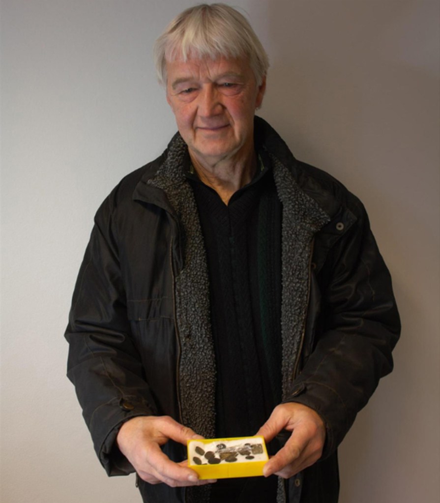 Jan Gunnar Fugelsnes holding a small yellow box with an unknown object inside.