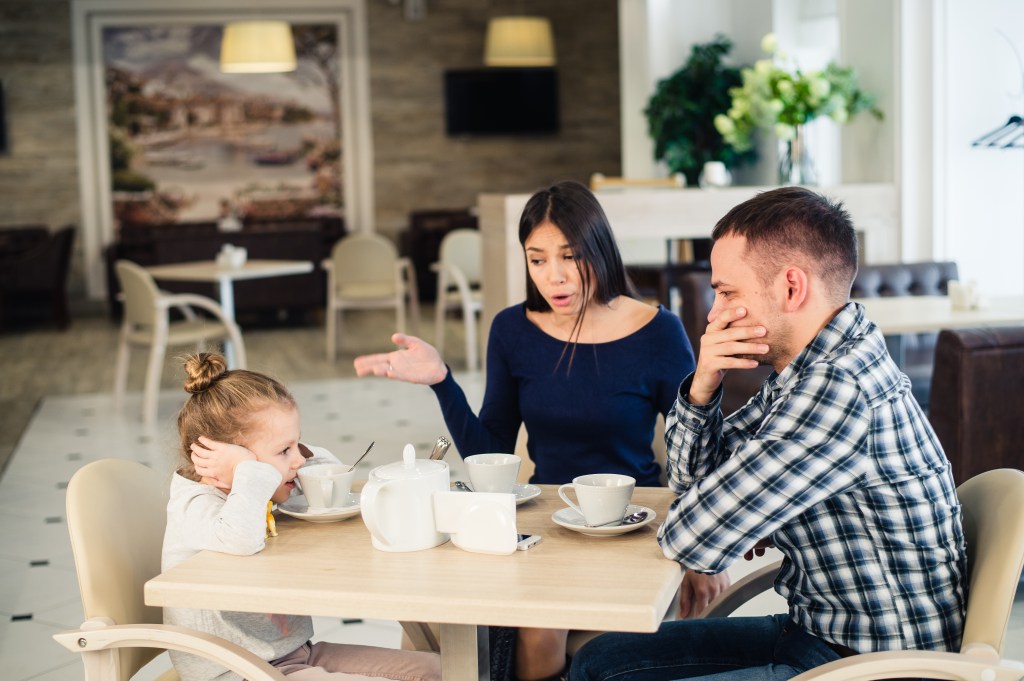 family at restaurant with upset child