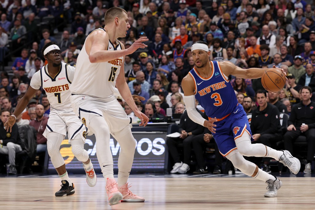 Josh Hart #3 of the New York Knicks drives against Nikola Jokic #15 of the Denver Nuggets during the first quarter at Ball Arena.