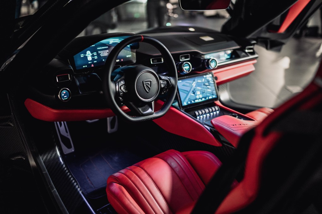 the view inside the Rimac Nevera  from the driver's seat, including the steering wheel and dashboard