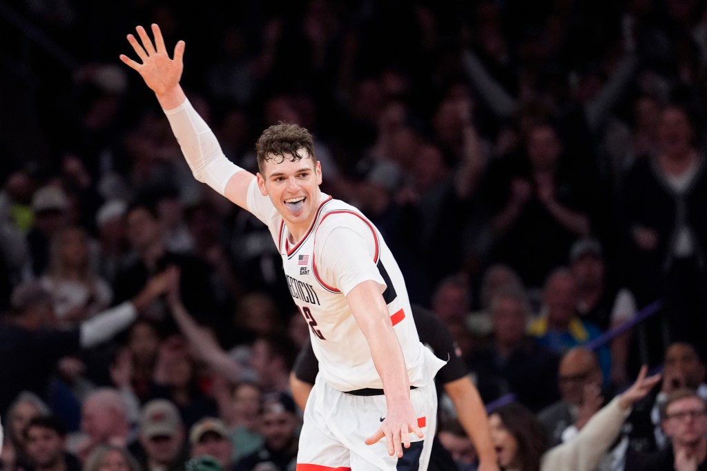 UConn center Donovan Clingan reacts after dunking during the second half of an NCAA college basketball game in the championship against Marquette of the Big East Conference tournament.