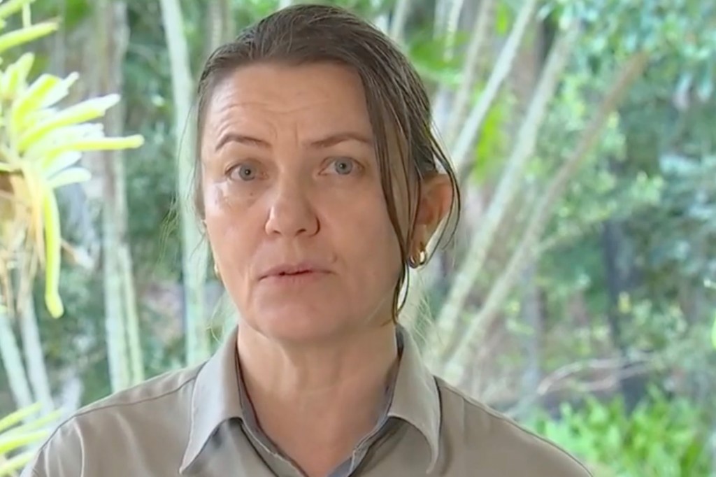 A woman with wet hair and an earring, identified as Fraser Coast Ranger, Linda Behrendorff, discussing a dingo attack incident on Yidney beachfront, K'gari.