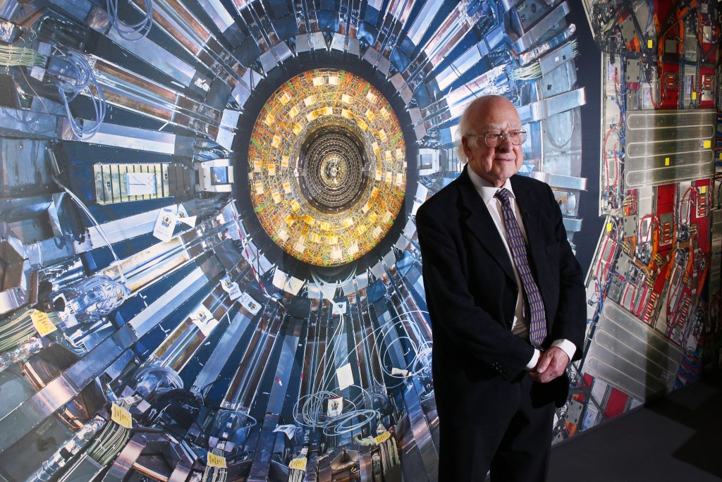 Professor Peter Higgs stands in front of a photograph of the Large Hadron Collider at the  Science Museum's 'Collider' exhibition on November 12, 2013 in London, England. 