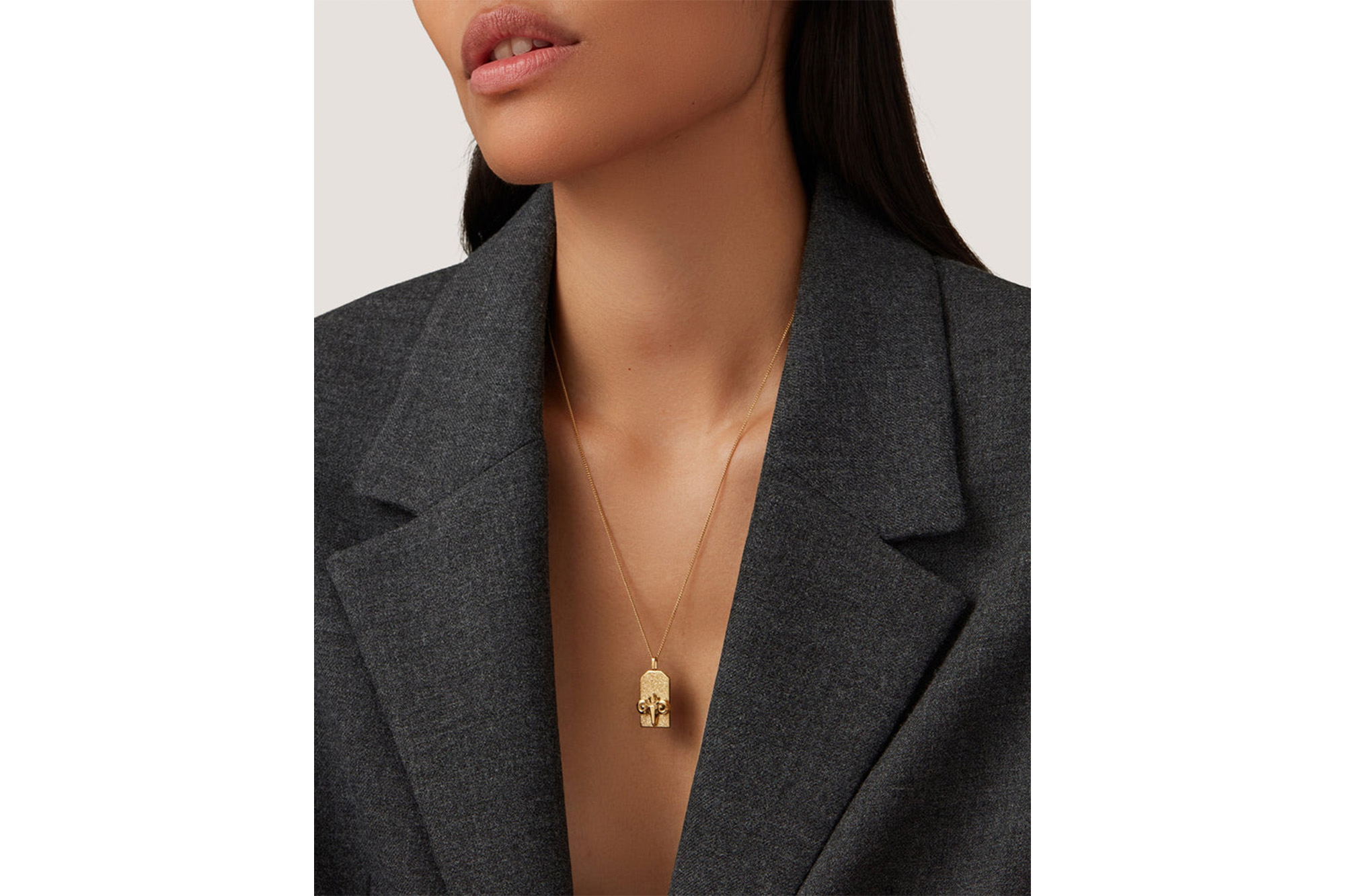 A model in a zodiac pendant necklace