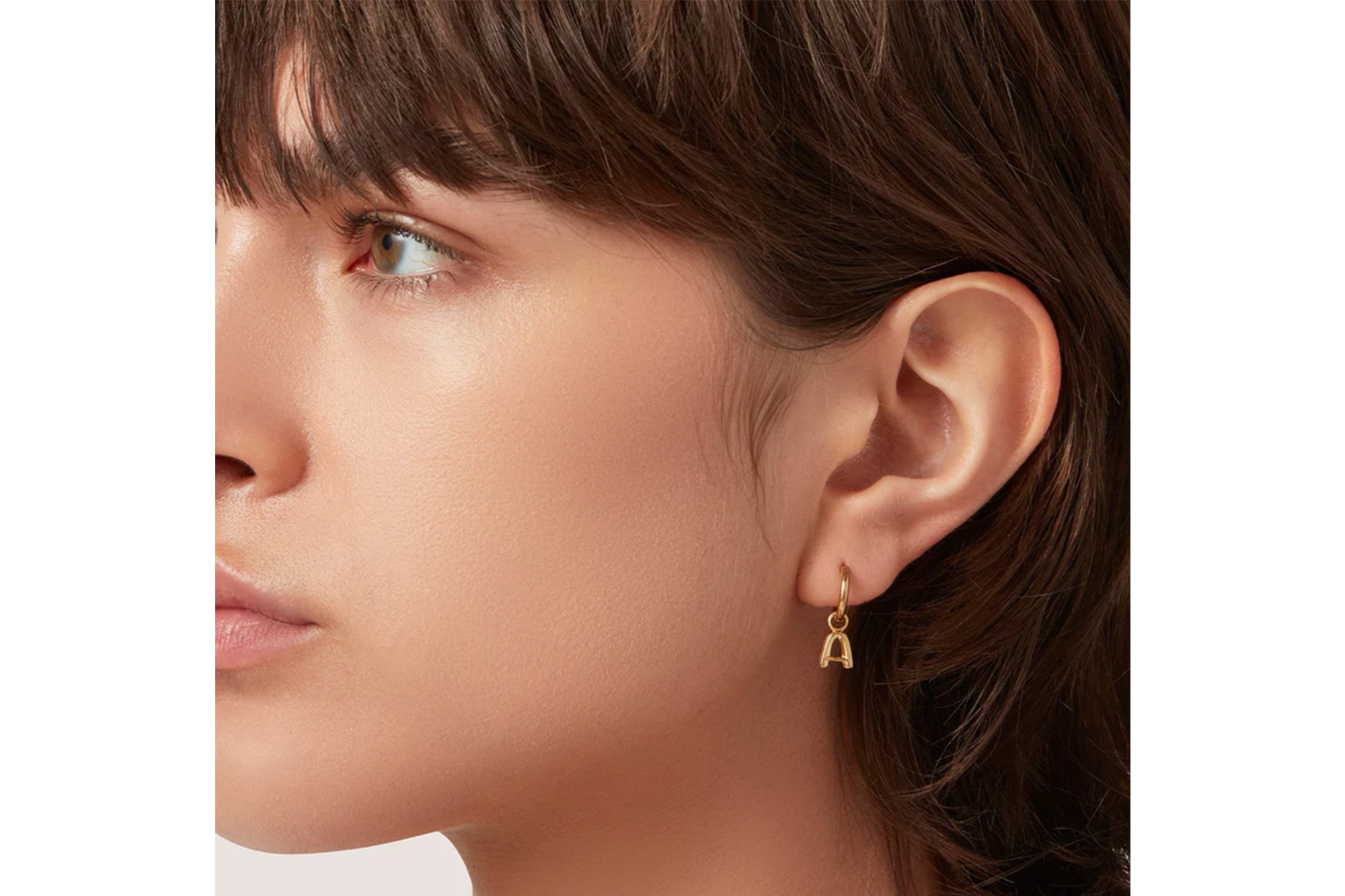 A model in an "A" huggie earring