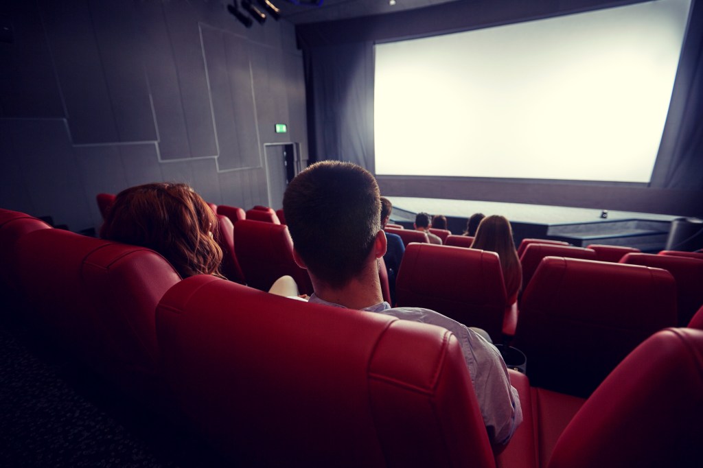 Couple watching movie in theater from back