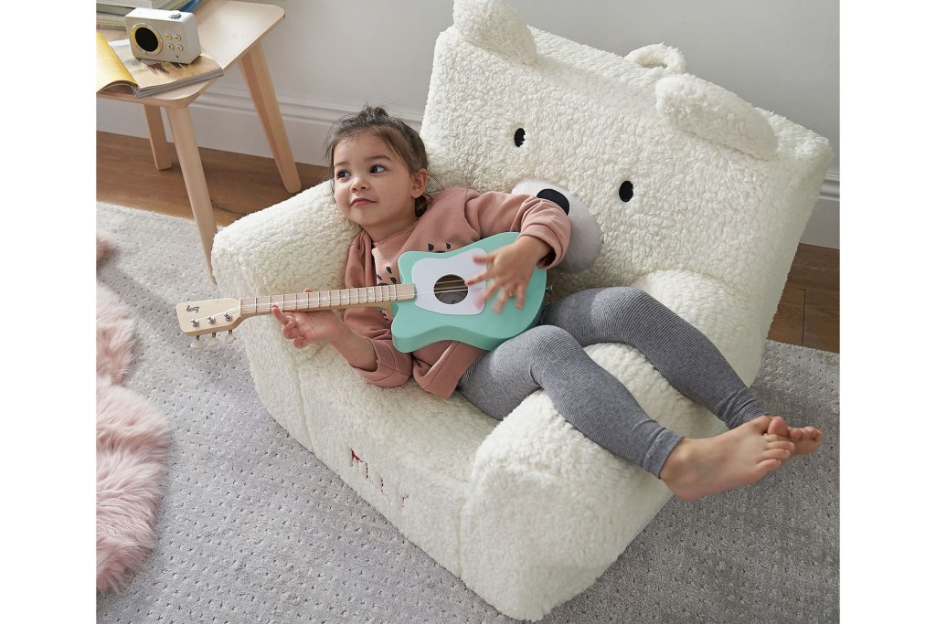 A girl sitting in a chair with a guitar