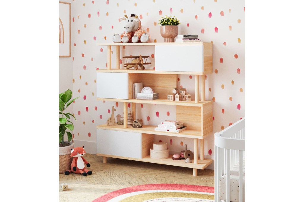 A shelf filled with toys beside a crib