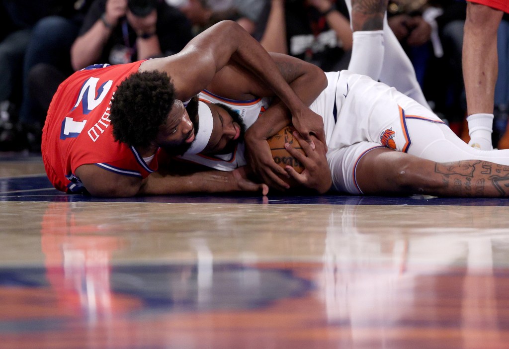 Mitchell Robinson fights Joel Embiid for a loose ball during the Knicks' victory. 