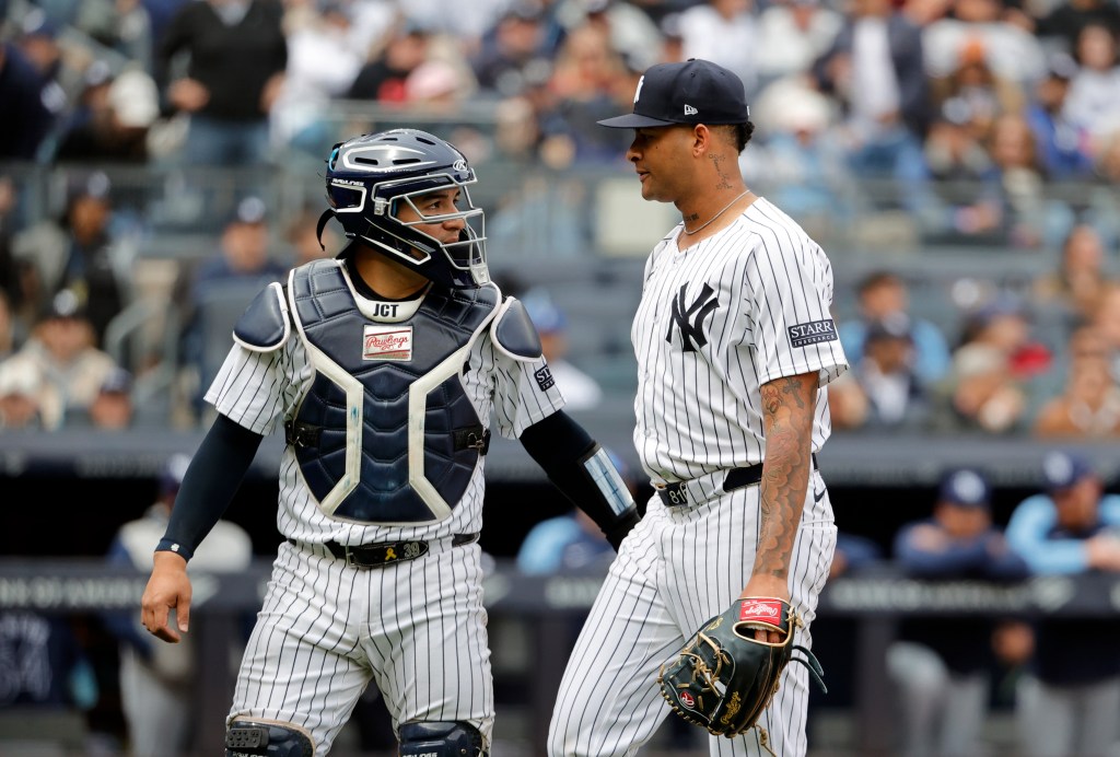 Yankees catcher Jose Trevino walks off the field with pitcher Luis Gil on Sunday.