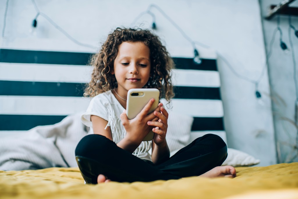 A little girl using a phone.