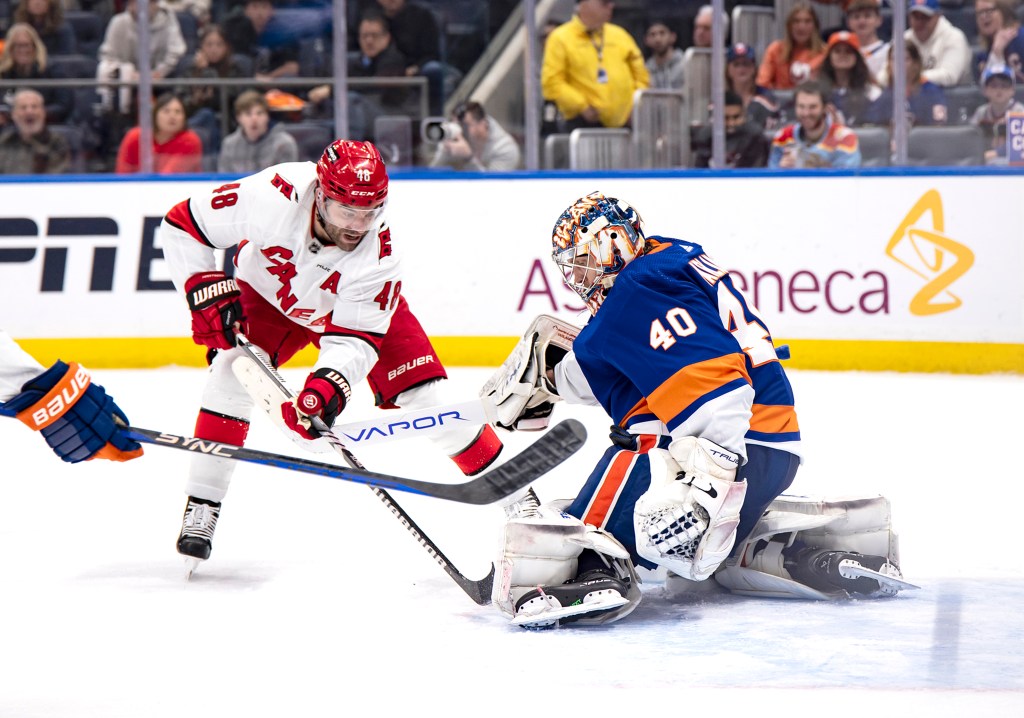 Semyon Varlamov of the New York Islanders makes a save against Jordan Martinook of the Carolina Hurricanes.