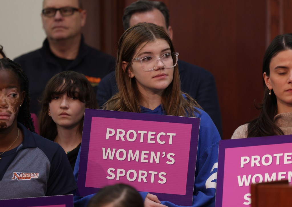 Avery Graziosi, 14, and a group of people holding signs at a press conference with Nassau County Executive Bruce Blakeman