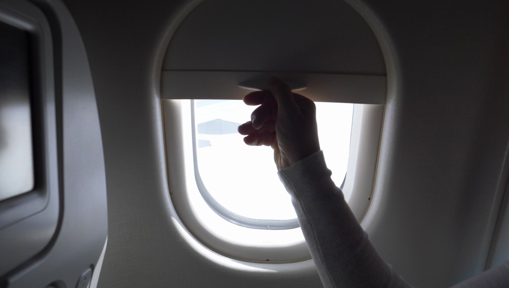 opening an airplane window shade