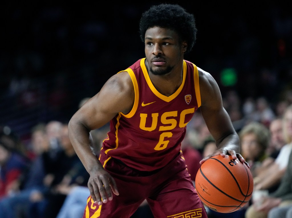 Bronny James, in his USC basketball uniform, dribbling the ball during a game against UCLA