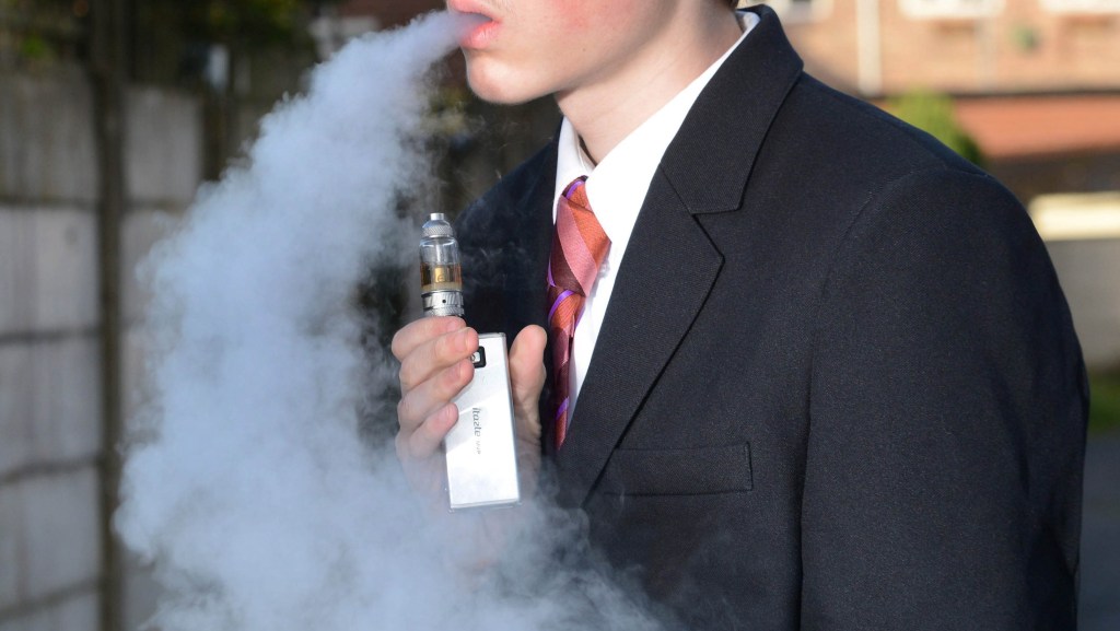 An anonymized school boy using a vaporizer