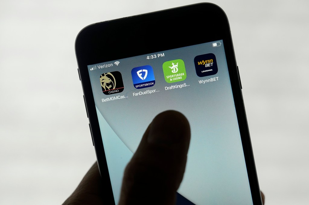 FanDuel, DraftKings and other online gambling apps are displayed on a phone.