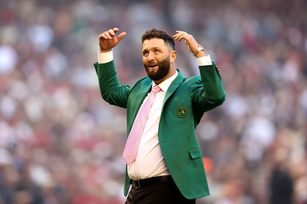 Golfer Jon Rahm waves to the crowd after throwing out a ceremonial first pitch before Game Four of the World Series