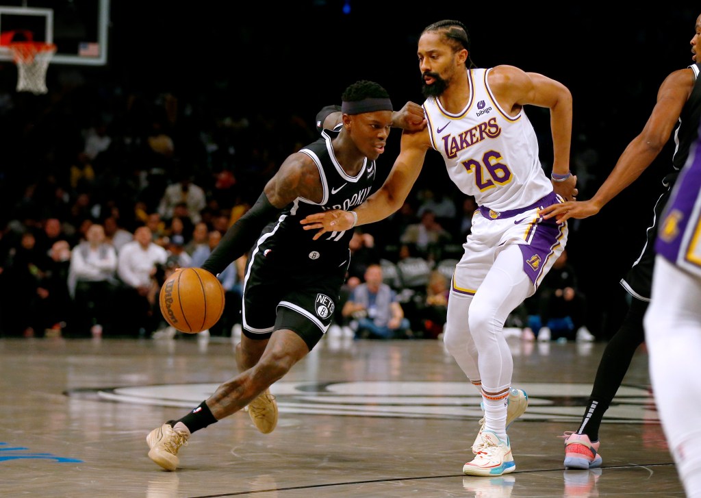 Brooklyn Nets guard Dennis Schroder, left, dribbles around Los Angeles Lakers guard Spencer Dinwiddie during the second half of an NBA basketball game Sunday