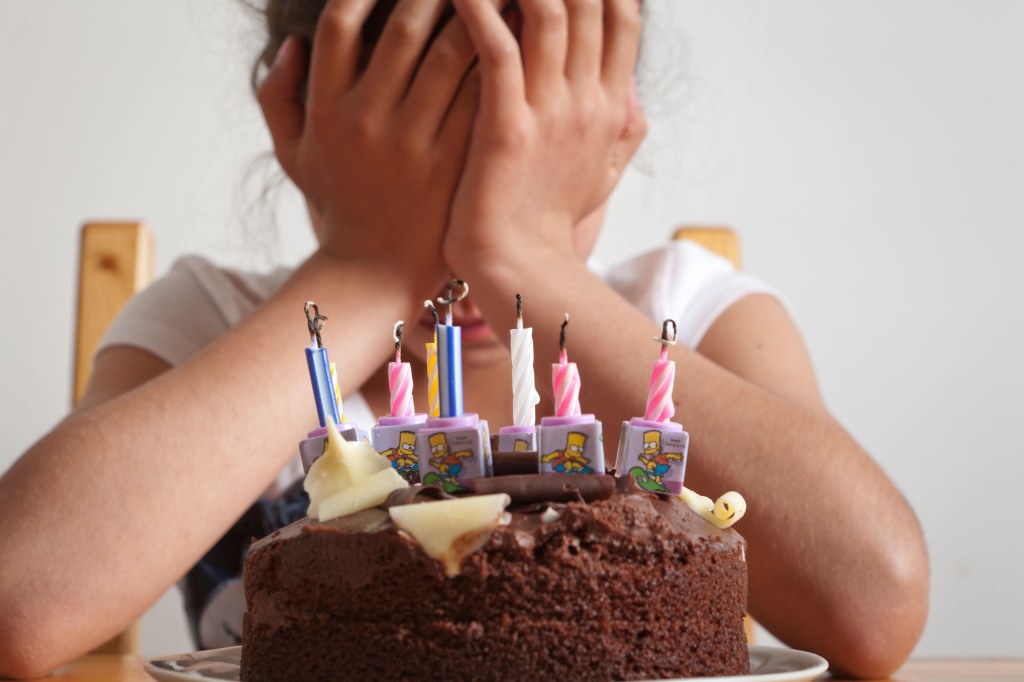 Birthday girl looking at candles on cake