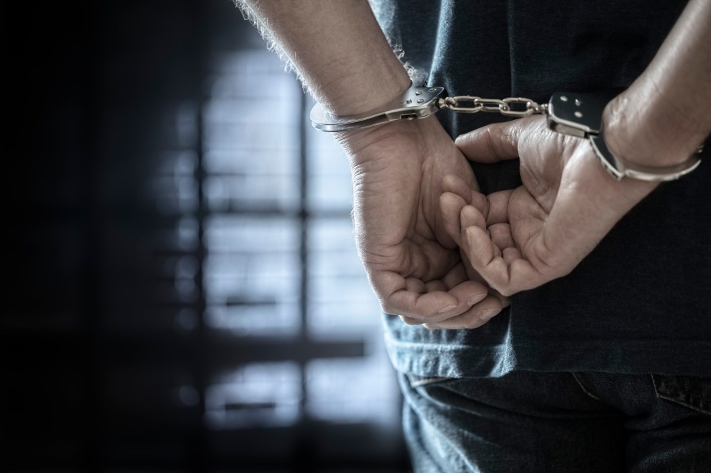 A stock photo of a man in handcuffs