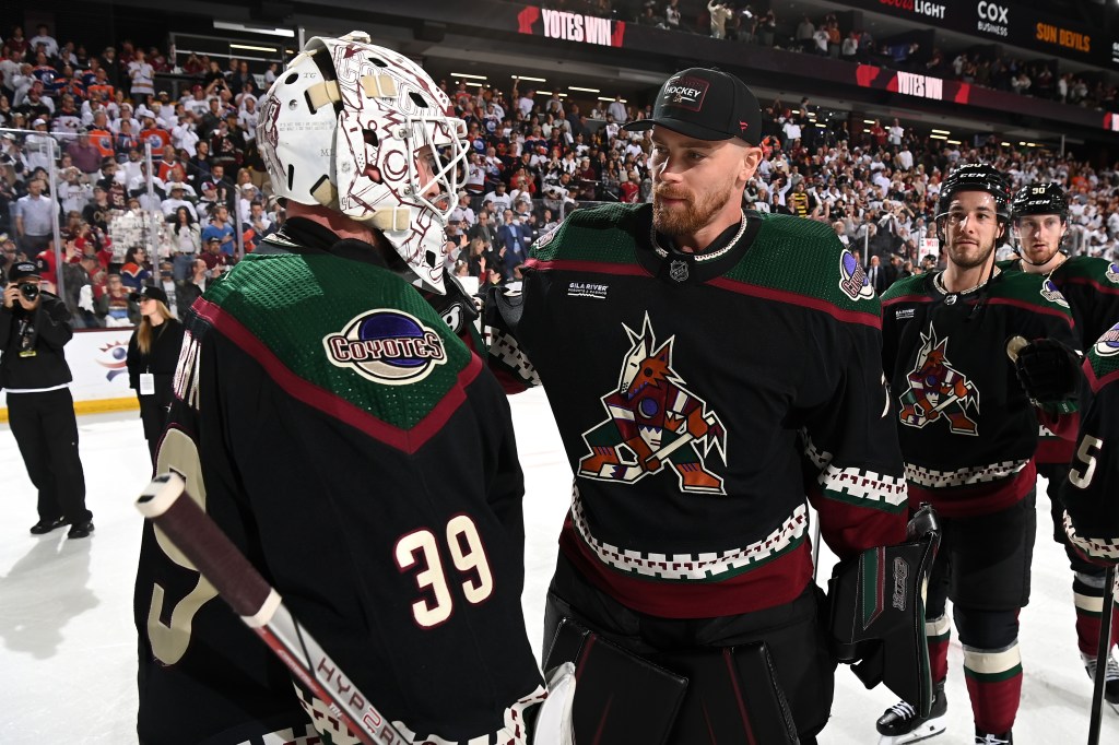 Connor Ingram #39 of the Arizona Coyotes celebrates with teammate Karel Vejmelka #70 after a 5-2 win against the Edmonton Oilers at Mullett Arena on April 17, 2024 in Tempe, Arizona.