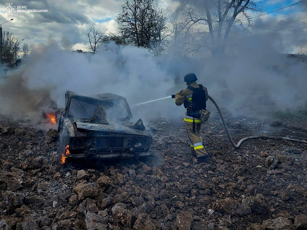 Firefighter extinguishing fire in a car destroyed during a Russian missile strike in Mykolaiv, Ukraine, March 17, 2024