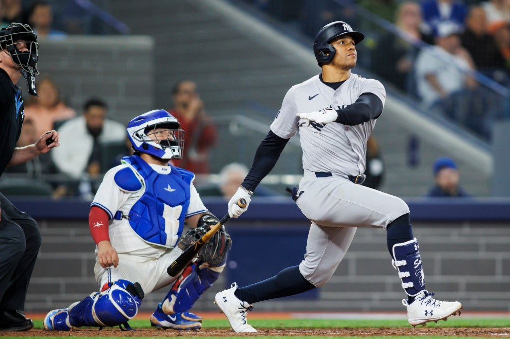 Juan Soto #22 of the New York Yankees watches the ball as he hits a solo home run in the eighth inning of their MLB game against the Toronto Blue Jays at Rogers Centre on April 17, 2024 in Toronto, Canada. 