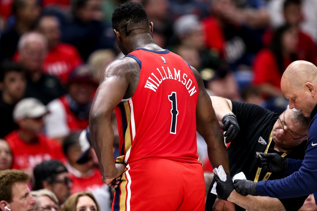 Pelicans forward Zion Williamson (1) gets medical attention during the first half against the Los Angeles Lakers in a play-in game of the 2024 NBA playoffs against the New Orleans Pelicans at Smoothie King Center. 