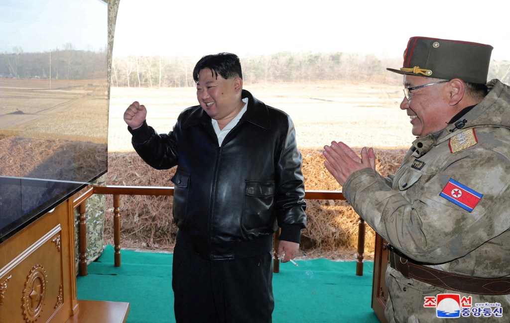 North Korean leader Kim Jong Un gestures and looks at a screen as he guides a training of the fire division.